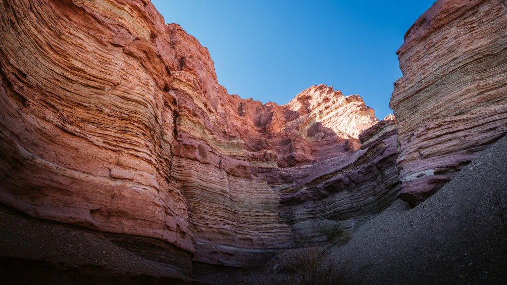 Wide view of a red rock canyon under a clear blue sky.